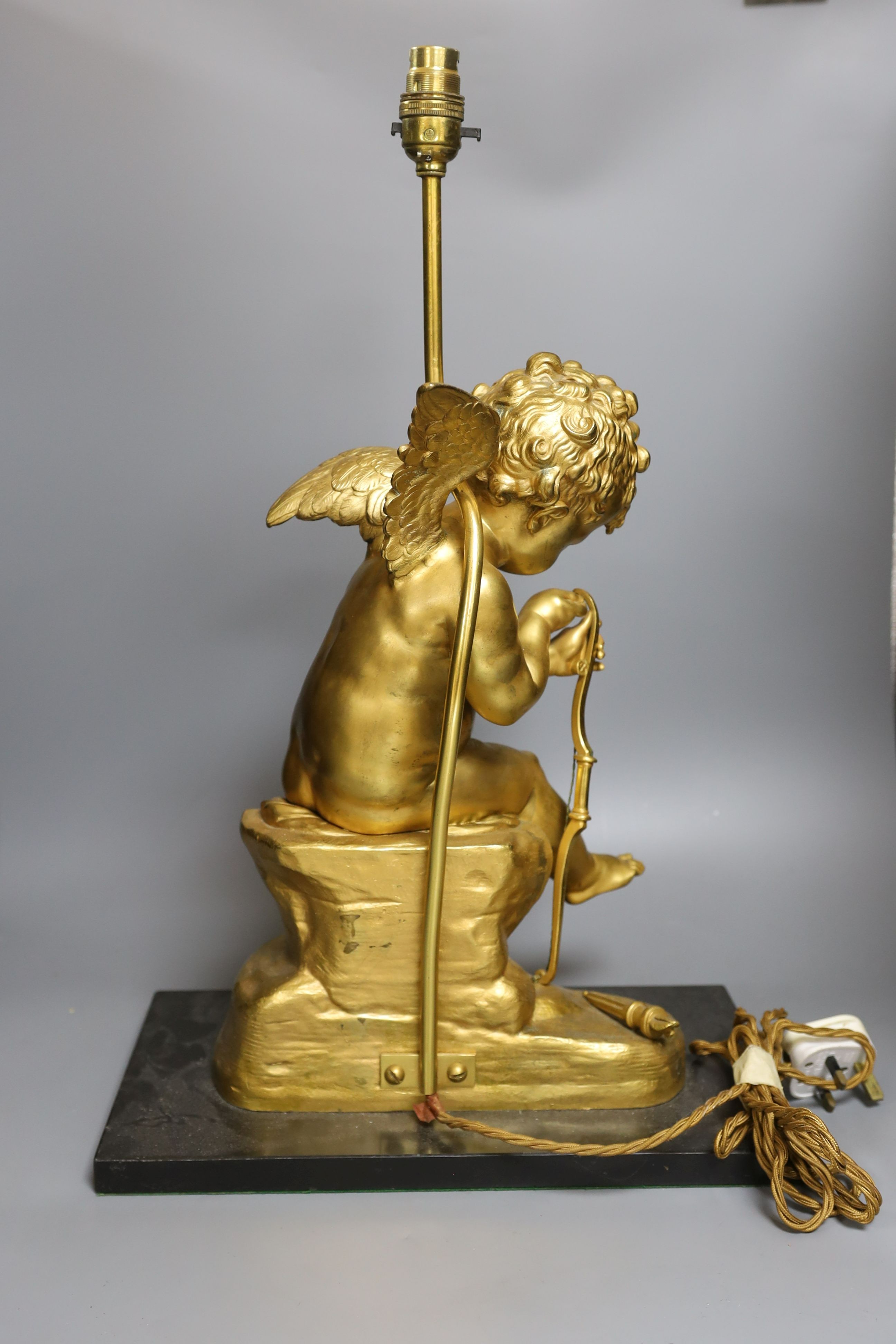 A gilt bronze seated Cupid figural lamp on mount - 58cm tall